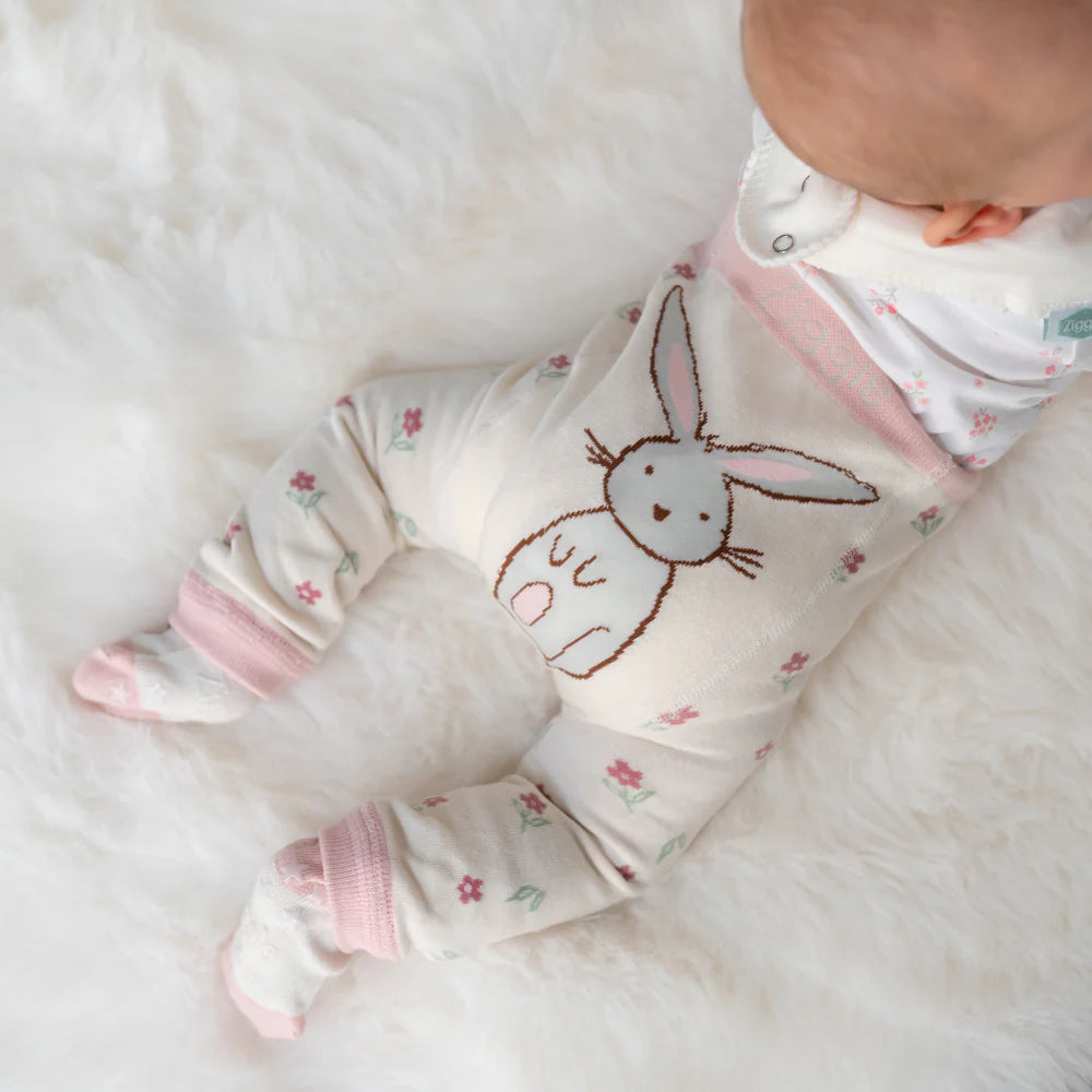Baby wearing a soft, white onesie with a bunny design