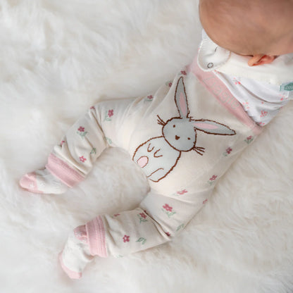 Baby wearing a soft, white onesie with a bunny design
