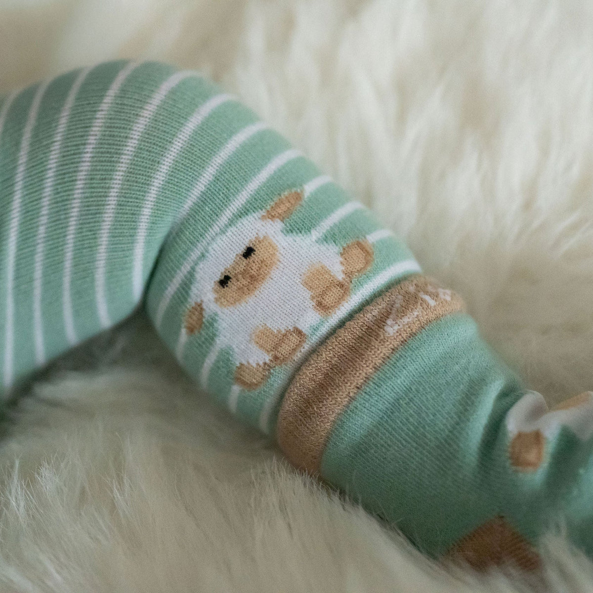 Green and white striped socks with bear design