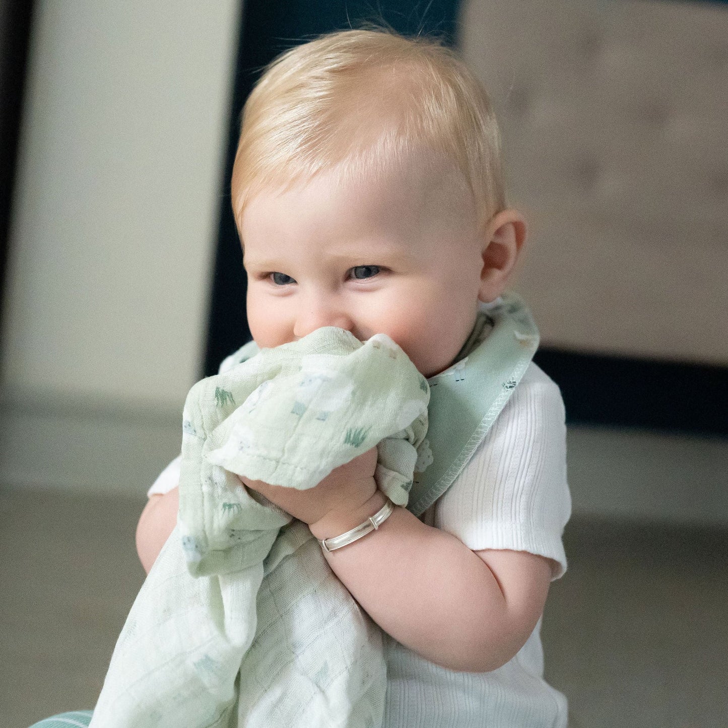 Baby holding a green blanket