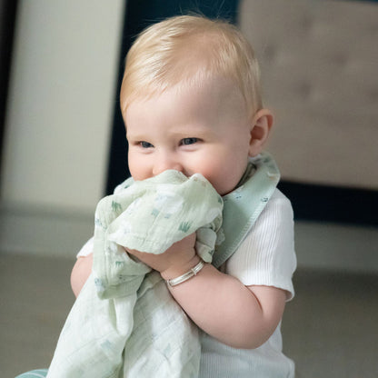 Baby holding a green blanket