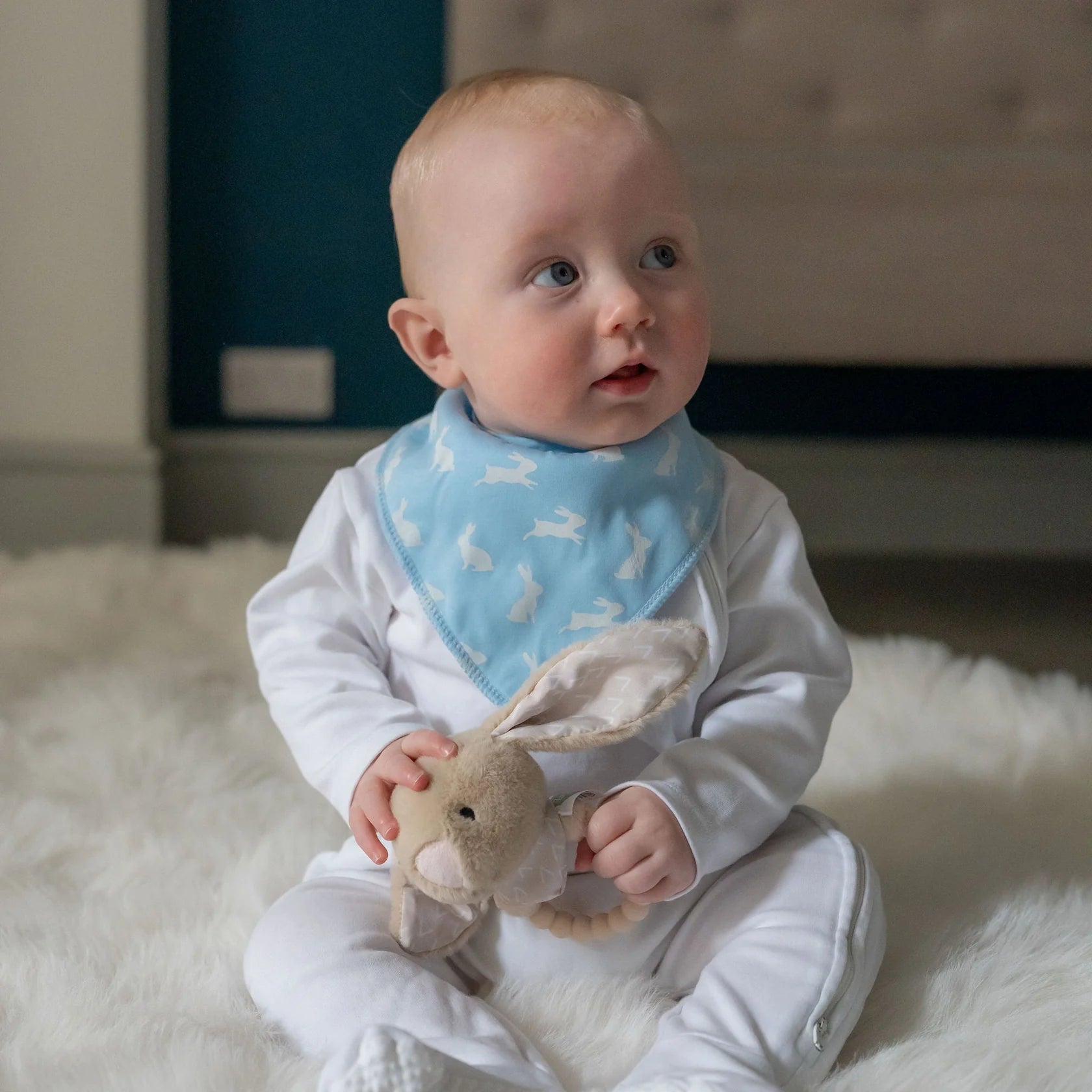 Baby wearing a blue bib with white patterns