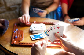 People playing cards at a table with a focus on hands and cards