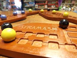 Wooden game board with marbles on a shelf background